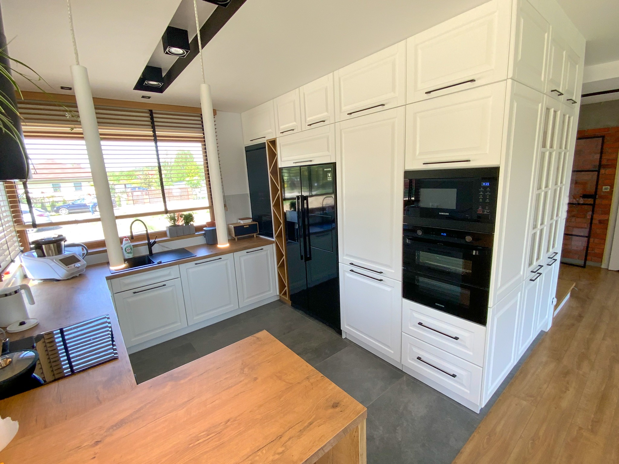 Przestronna kuchnia na wymiar otwarta na salon - harmonijne połączenie przestrzeni.