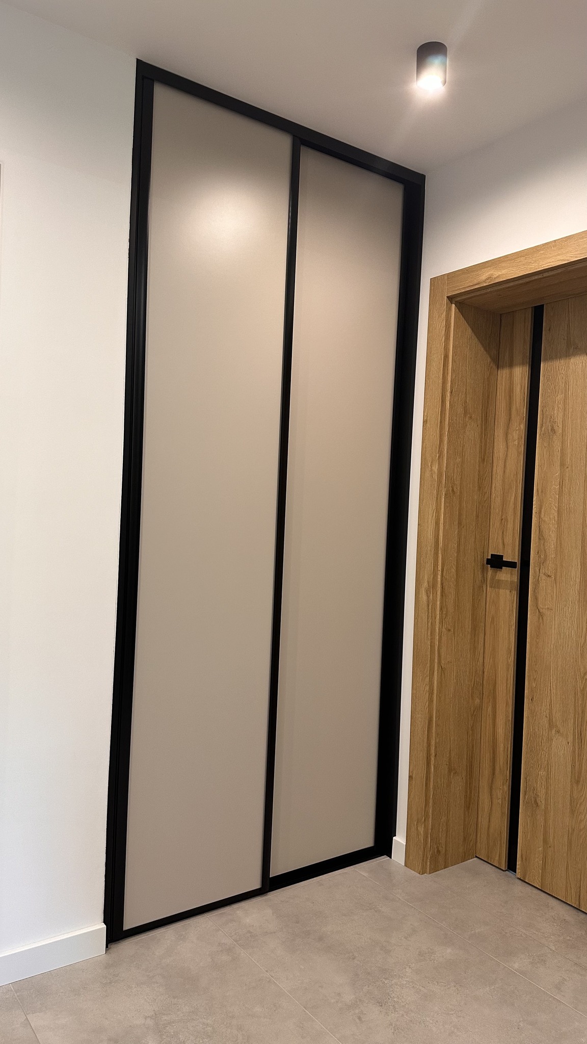 Drzwi z zabudową w nowoczesnym stylu – harmonia drewna i czerni.