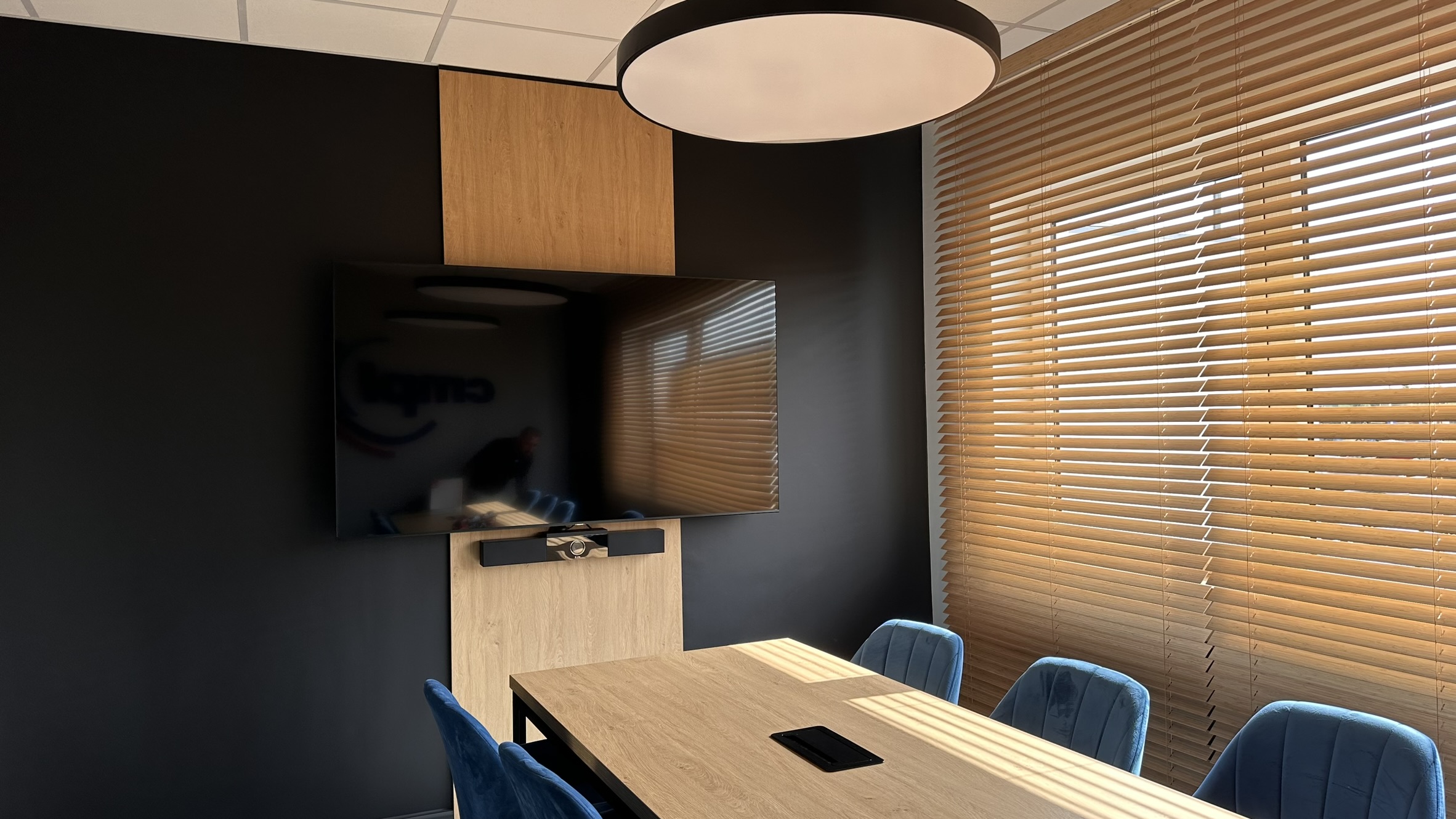 Drewniana zabudowa telewizora w przestrzeni biurowej CMPL